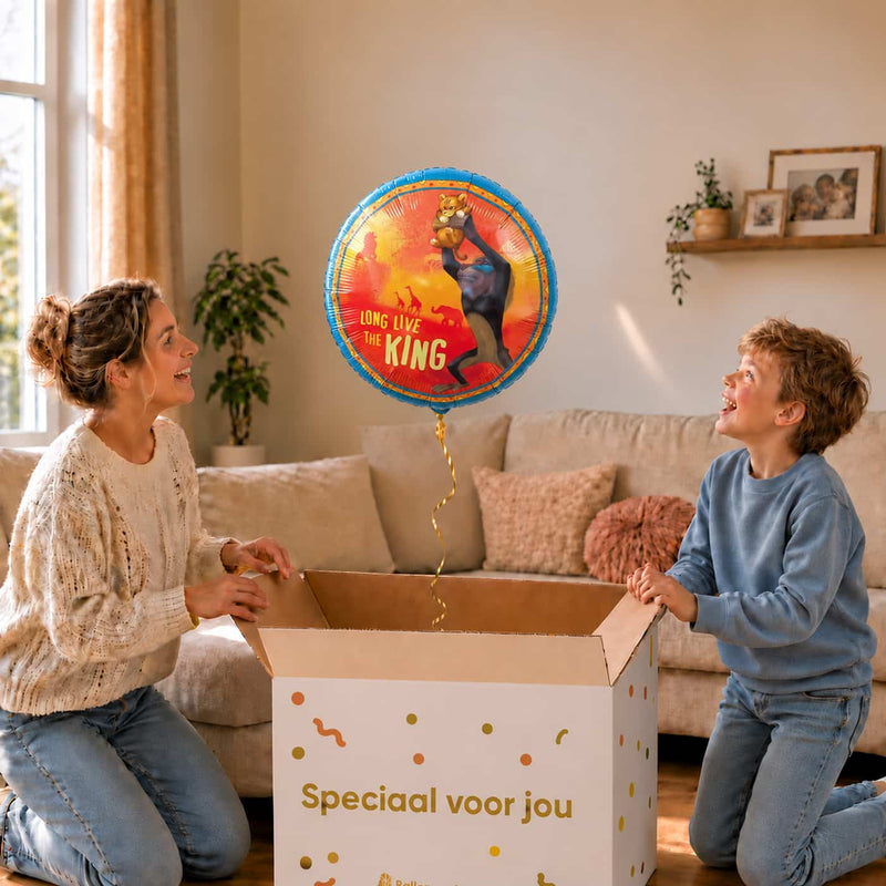 Moeder en jongetje bewonderen een Lion King heliumballon van 46 cm boven een open cadeaudoos.