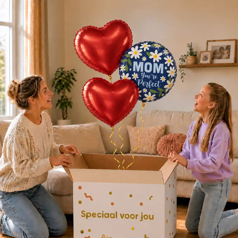 Mom You're Perfect Trosje: moeder en dochter pakken het heliumgevulde ballonnentrosje uit een Speciaal voor jou-doos, met natuurlijk gekrulde gouden linten.