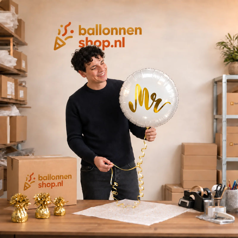 Jesse houdt de Mr Helium Ballon Goud vast in de warme werkplaats van Ballonnenshop.nl.