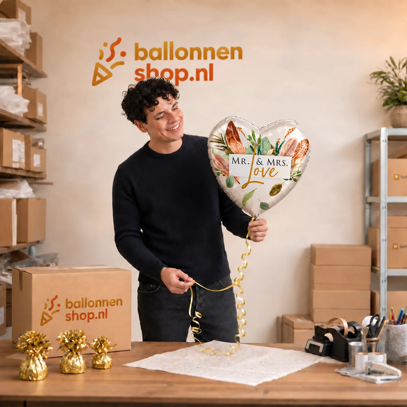 Jesse houdt de Mr & Mrs Love Helium Ballon vast in de warme werkplaats van Ballonnenshop.nl.