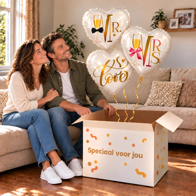 Een feestelijk huwelijksmoment met Mr & Mrs Love Trosje Ballonnen boven een open Speciaal voor jou-doos in een warme woonkamer.