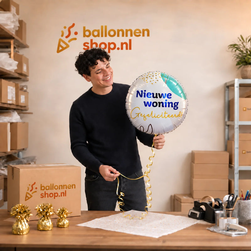 Jesse houdt de Nieuwe Woning Gefeliciteerd vast in de warme werkplaats van Ballonnenshop.nl.