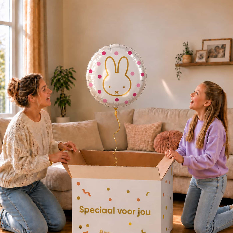 Moeder en meisje openen een cadeaudoos met een Nijntje heliumballon van 46 cm met roze stippen.
