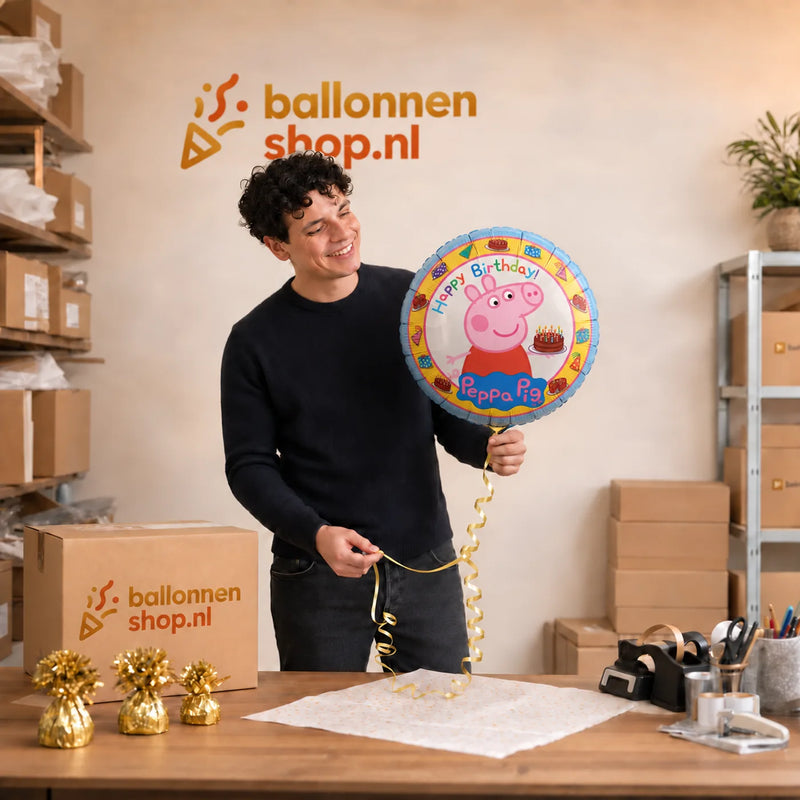 Jesse houdt de Peppa Pig Happy Birthday Ballon vast in de warme werkplaats van Ballonnenshop.nl.
