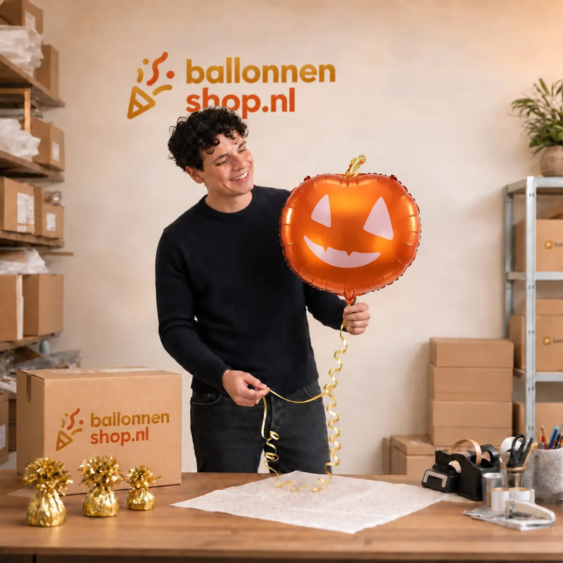 Jesse houdt de Pompoen Helium Ballon vast in de warme werkplaats van Ballonnenshop.nl.