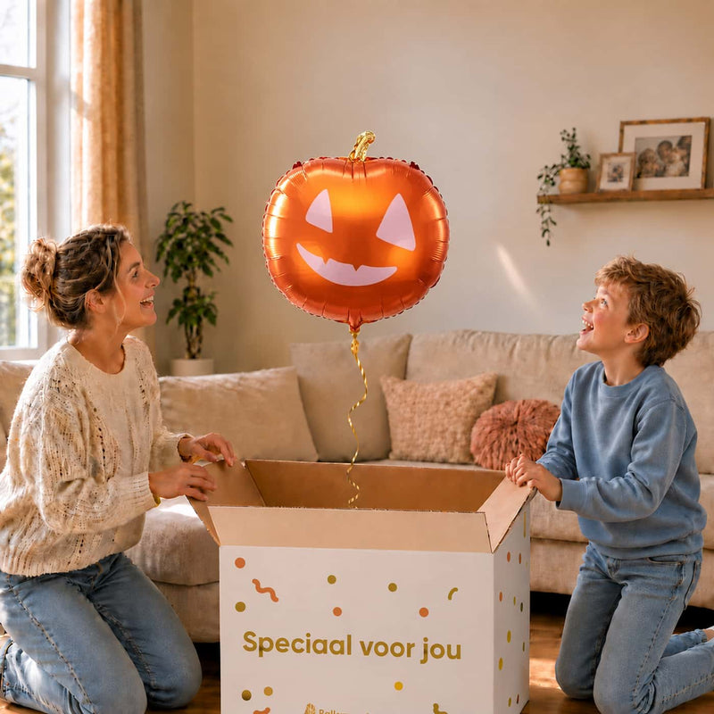 Moeder en jongen pakken de oranje pompoenballon van 45 cm uit de cadeaudoos.