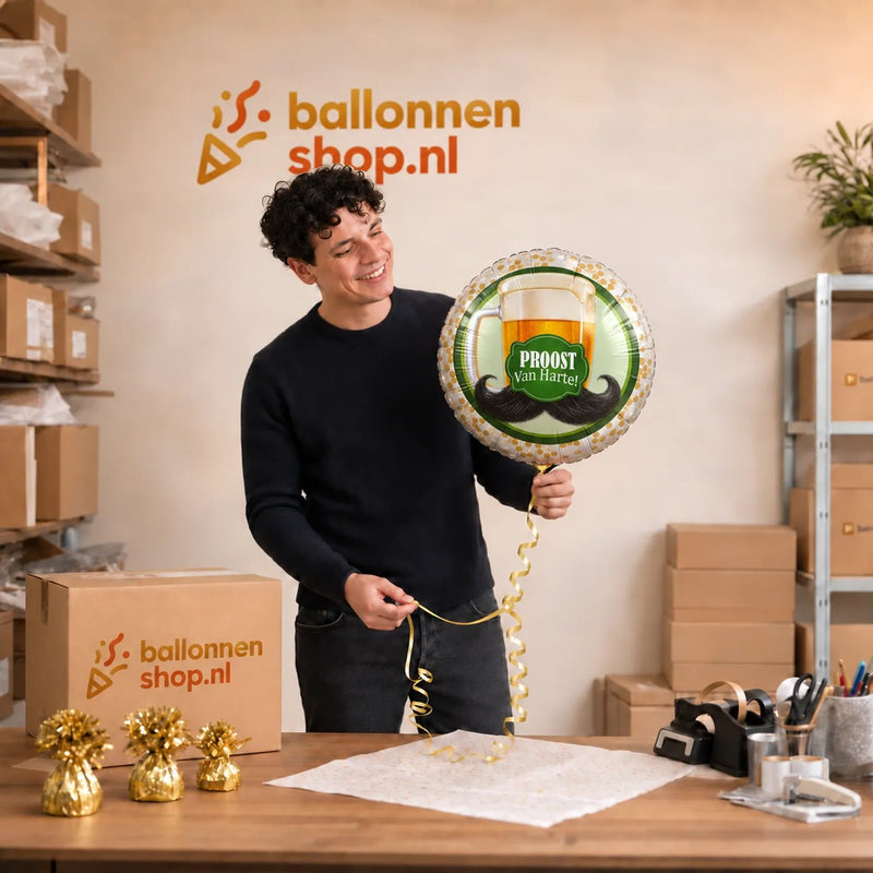 Jesse houdt de Proost Van Harte Helium Ballon vast in de warme werkplaats van Ballonnenshop.nl.