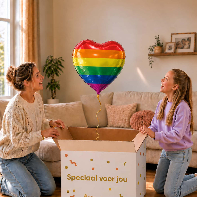 Moeder en meisje pakken de hartvormige regenboogballon van 45 cm uit de cadeaudoos.