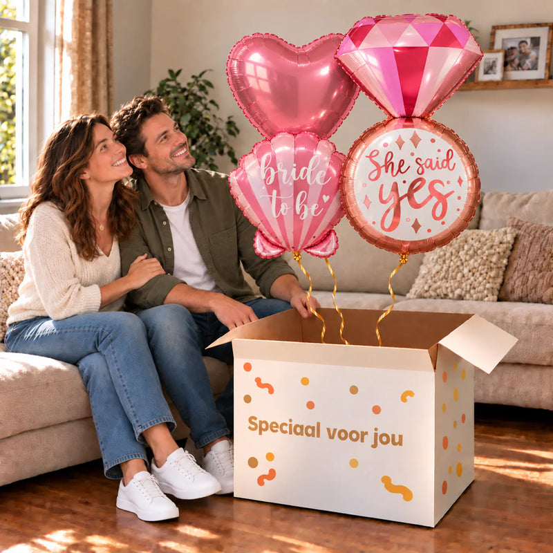 Een feestelijk huwelijksmoment met She Said Yes XL Trosje Ballonnen boven een open Speciaal voor jou-doos in een warme woonkamer.