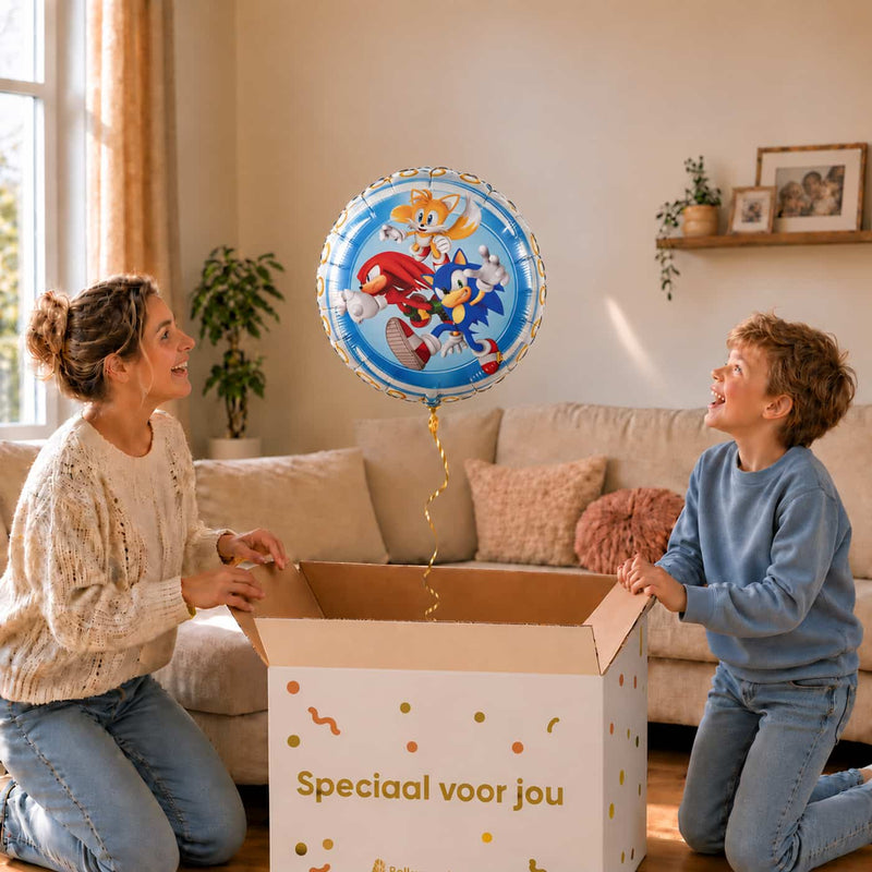 Moeder en jongen pakken een Sonic, Knuckles en Tails heliumballon van 46 cm uit de cadeauverpakking.