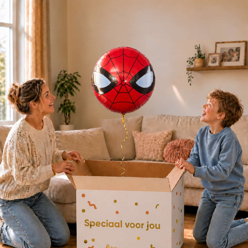 Jongen en moeder bekijken een ronde rode Spider-Man maskerballon van 46 cm boven de cadeaudoos.