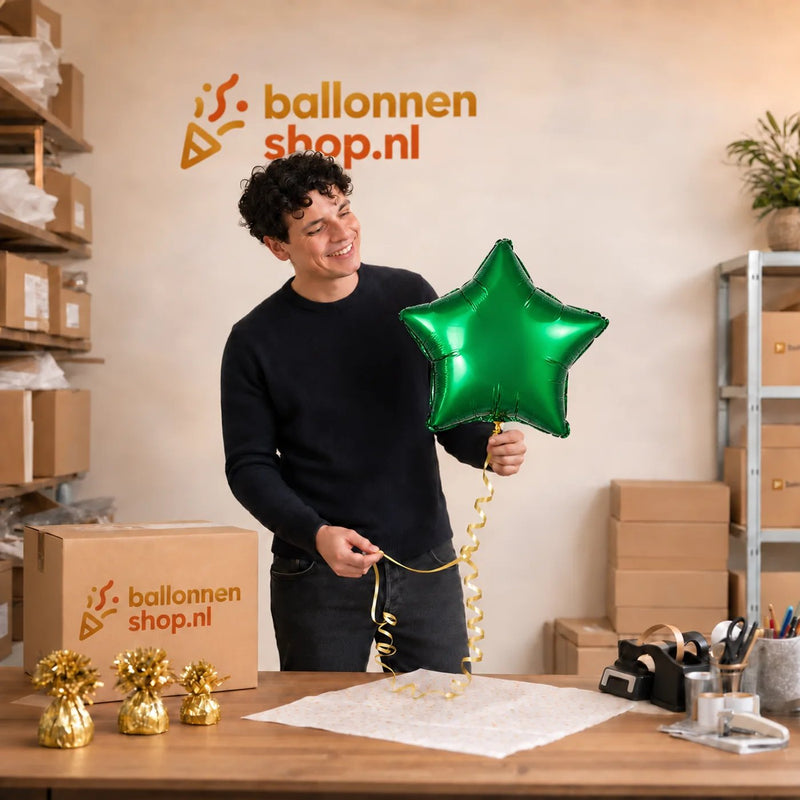 Jesse houdt de Ster Groen Helium Ballon vast in de warme werkplaats van Ballonnenshop.nl.