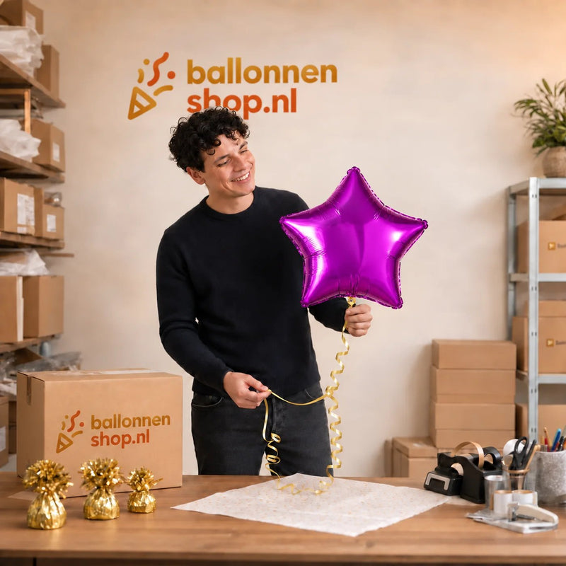 Jesse houdt de Ster Paars Helium Ballon vast in de warme werkplaats van Ballonnenshop.nl.