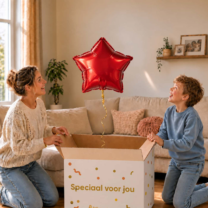 Moeder en jongen pakken een rode sterballon van 46 cm uit de cadeaudoos.