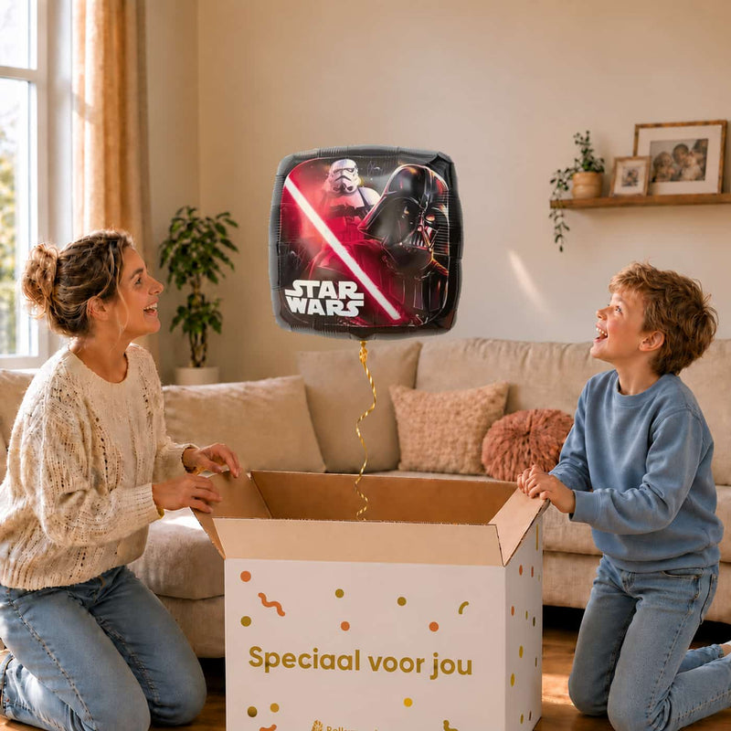 Moeder en jongen bekijken de ballon The Dark Side Star Wars Ballon in zacht warm licht boven de geopende cadeaudoos ‘Speciaal voor jou’.