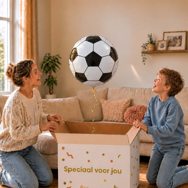 Moeder en jongen openen een cadeaudoos met een zwart-witte voetbal heliumballon van 45 cm.