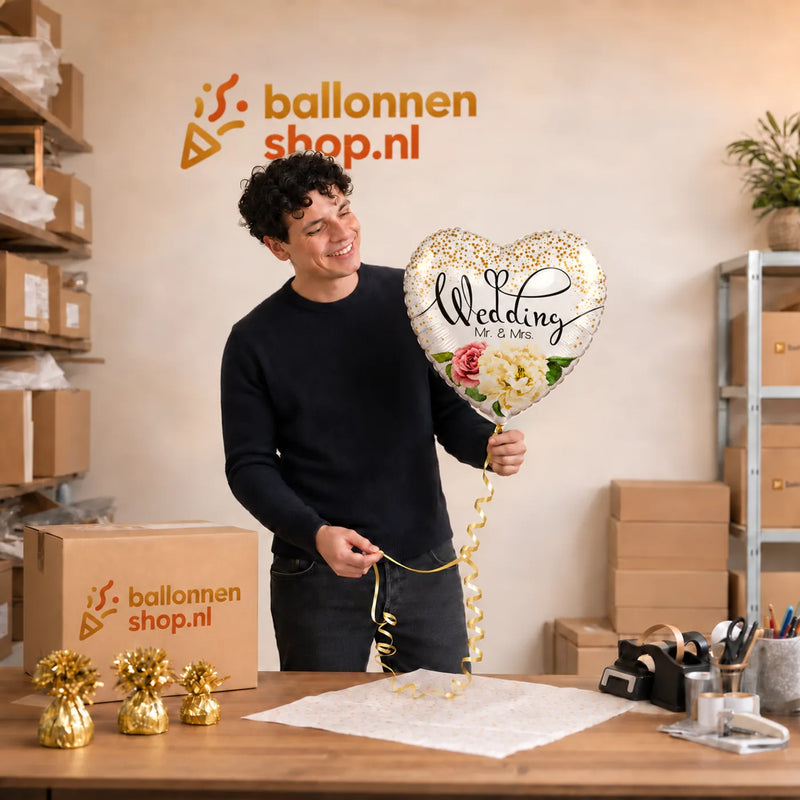 Jesse houdt de Wedding Mr & Mrs Helium Ballon vast in de warme werkplaats van Ballonnenshop.nl.