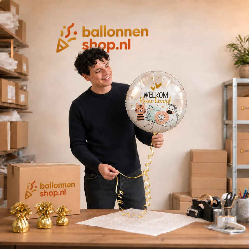 Jesse houdt de Welkom Kleine Lieverd Ballon vast in de warme werkplaats van Ballonnenshop.nl.