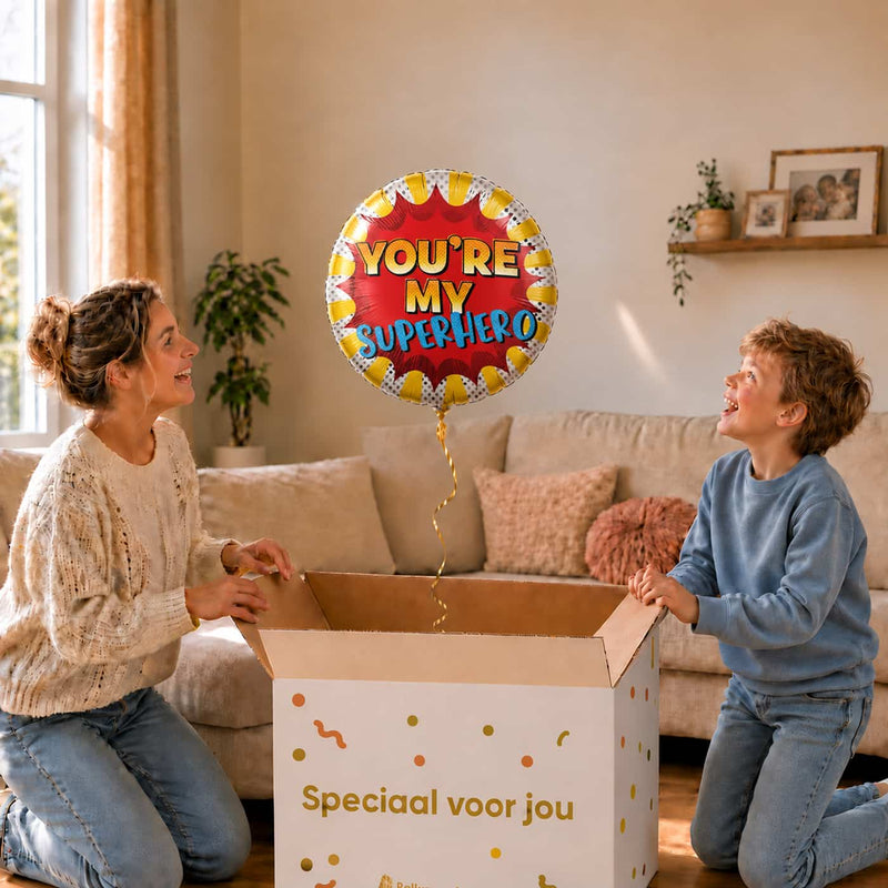 Moeder en jongen openen een cadeaudoos met een You're My Superhero heliumballon van 45 cm.