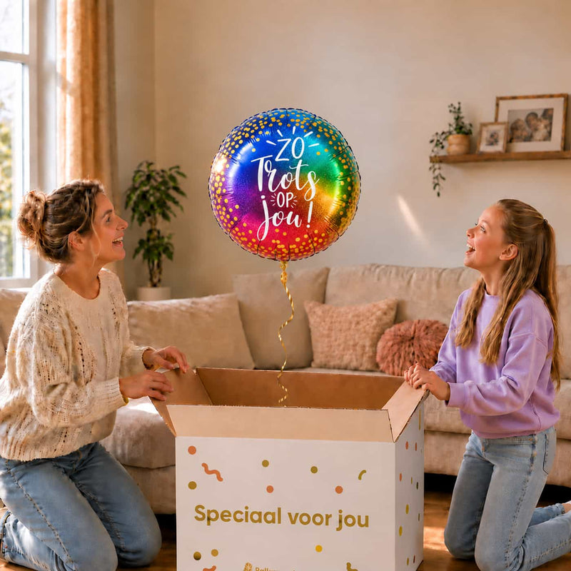 Moeder en meisje openen een cadeaudoos met een Zo Trots Op Jou heliumballon van 46 cm in regenboogkleuren.