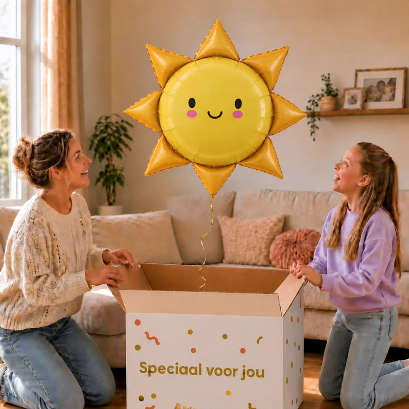Moeder en dochter openen een feestelijke doos met de Zonneschijn voor jou heliumballon van 96 cm.