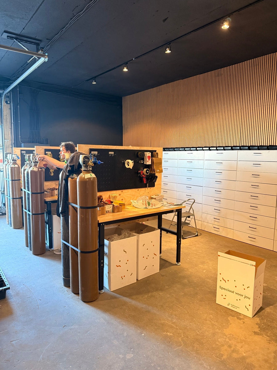 Aan het werk in het nieuwe pand van Ballonnenshop, met heliumflessen, werkbanken en balloncadeaudozen.