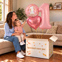 Een jarige met 1 Jaar XL Trosje Roze boven een open Speciaal voor jou-doos in een warme woonkamer.
