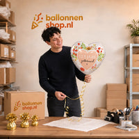 Jesse houdt de 12.5 Jaar Getrouwd Helium Ballon vast in de warme werkplaats van Ballonnenshop.nl.