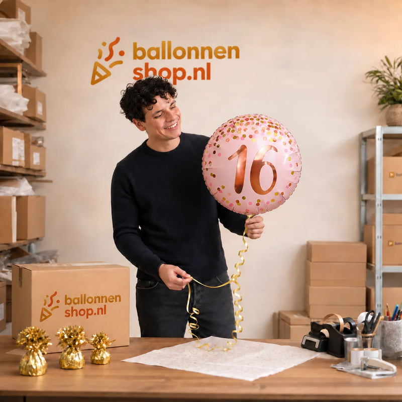 Jesse houdt de 16 Jaar Helium Ballon Roze vast in de warme werkplaats van Ballonnenshop.nl.