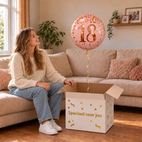 Vrouw viert 18 jaar met 18 Jaar Helium Ballon Roze uit een cadeaudoos van Ballonnenshop.nl