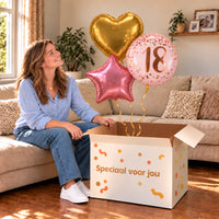 Een jarige met 18 Jaar Trosje Roze/Goud/Rose Goud boven een open Speciaal voor jou-doos in een warme woonkamer.