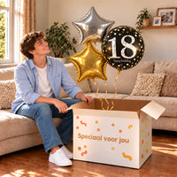 Een jarige met 18 Jaar Trosje Zilver/Zwart/Goud boven een open Speciaal voor jou-doos in een warme woonkamer.