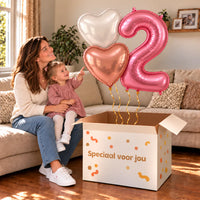 Een jarige met 2 Jaar Mat Roze Hartjes Tros boven een open Speciaal voor jou-doos in een warme woonkamer.