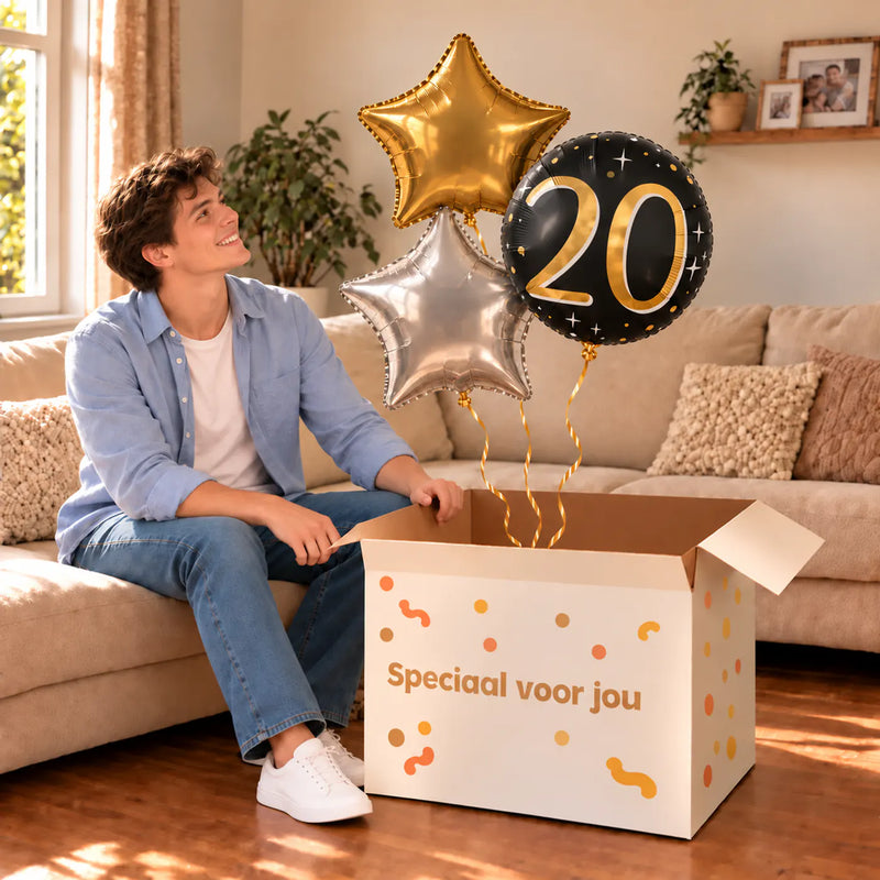 Een jarige met 20 Jaar Trosje Zilver/Zwart/Goud boven een open Speciaal voor jou-doos in een warme woonkamer.