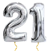 21 Jaar Cijfer Ballonnen Zilver – heliumgevulde ballonnen met dunne gouden lintjes op een witte achtergrond