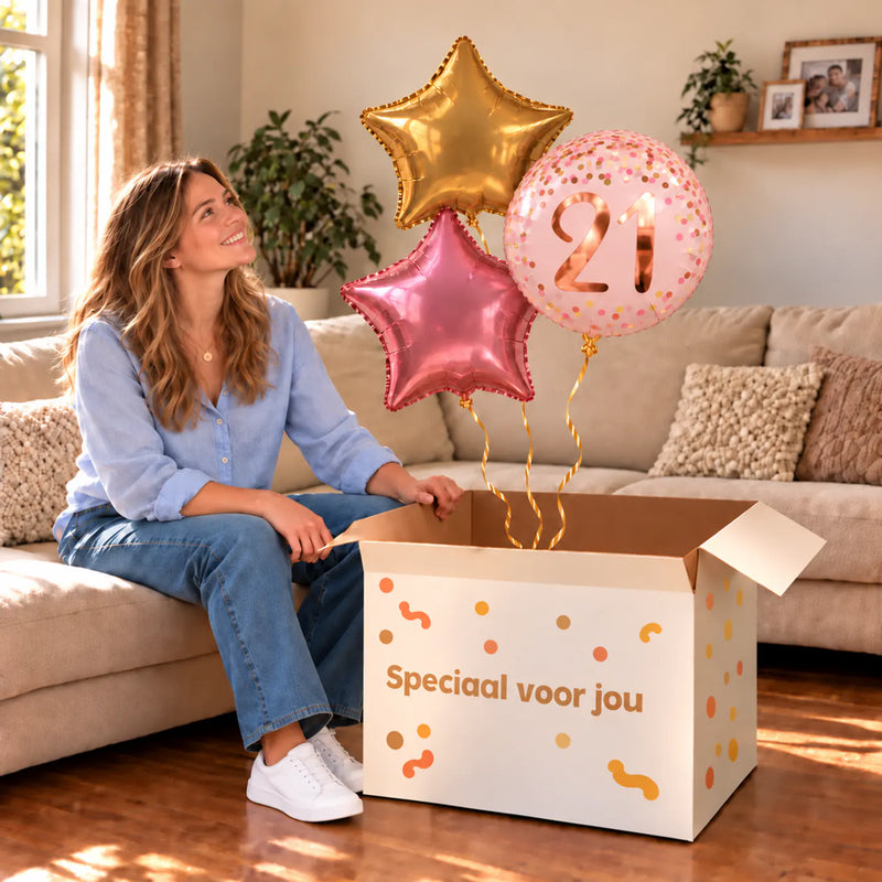 Een jarige met 21 Jaar Trosje Roze/Goud/Rose Goud boven een open Speciaal voor jou-doos in een warme woonkamer.