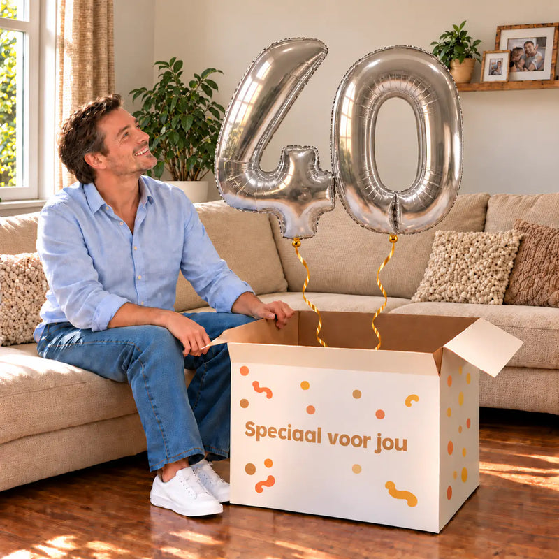 40 Jaar Cijfer Ballonnen Zilver met twee heliumgevulde cijferballonnen en een jarige in een warme woonkamer