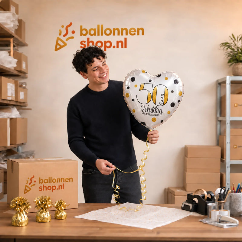 Jesse houdt de 50 Jaar Getrouwd Helium Ballon vast in de warme werkplaats van Ballonnenshop.nl.