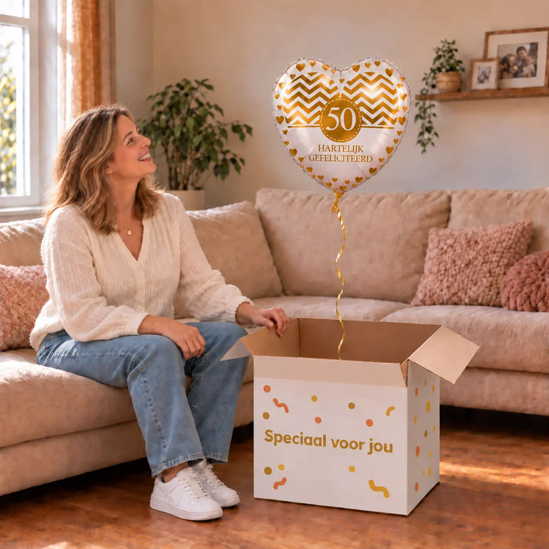 Vrouw viert 50 jaar met 50 Jaar Hartelijk Gefeliciteerd uit een cadeaudoos van Ballonnenshop.nl