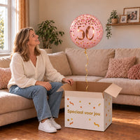 Vrouw viert 50 jaar met 50 Jaar Helium Ballon Roze uit een cadeaudoos van Ballonnenshop.nl