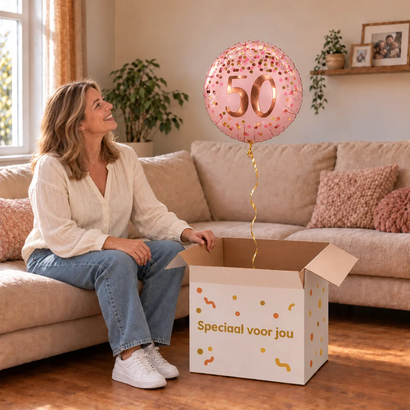 Vrouw viert 50 jaar met 50 Jaar Helium Ballon Roze uit een cadeaudoos van Ballonnenshop.nl