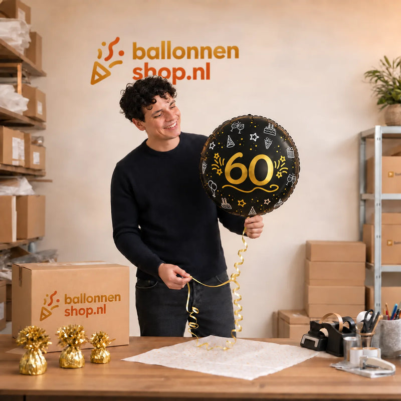 Jesse houdt de 60 Ballon Zwart/Zilver/Goud vast in de warme werkplaats van Ballonnenshop.nl.
