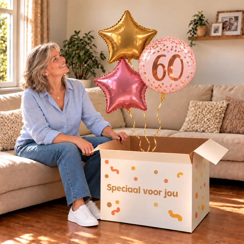 Een jarige met 60 Jaar Trosje Roze/Goud/Rose Goud boven een open Speciaal voor jou-doos in een warme woonkamer.