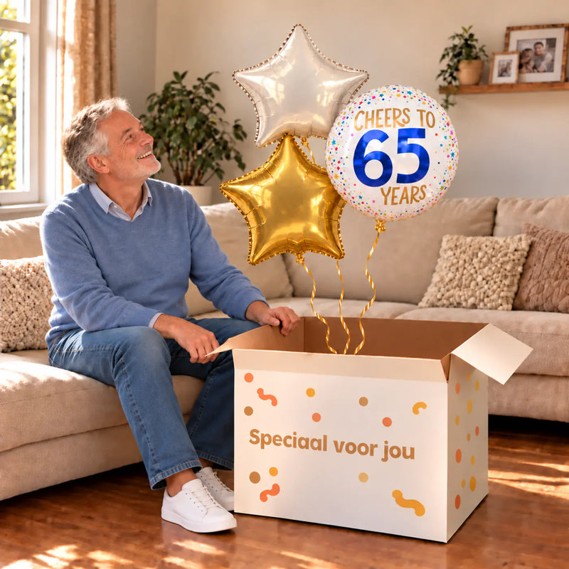 Een jarige met 65 Jaar Trosje Wit/Goud/Blauw boven een open Speciaal voor jou-doos in een warme woonkamer.