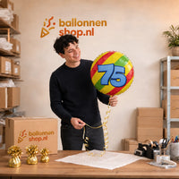 Jesse houdt de 75 Jaar Helium Ballon vast in de warme werkplaats van Ballonnenshop.nl.
