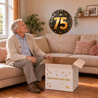 Man viert 75 jaar met 75 Jaar Goud/Zwart Helium Ballon uit een cadeaudoos van Ballonnenshop.nl