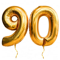 90 Jaar Cijfer Ballonnen Goud – heliumgevulde ballonnen met dunne gouden lintjes op een witte achtergrond