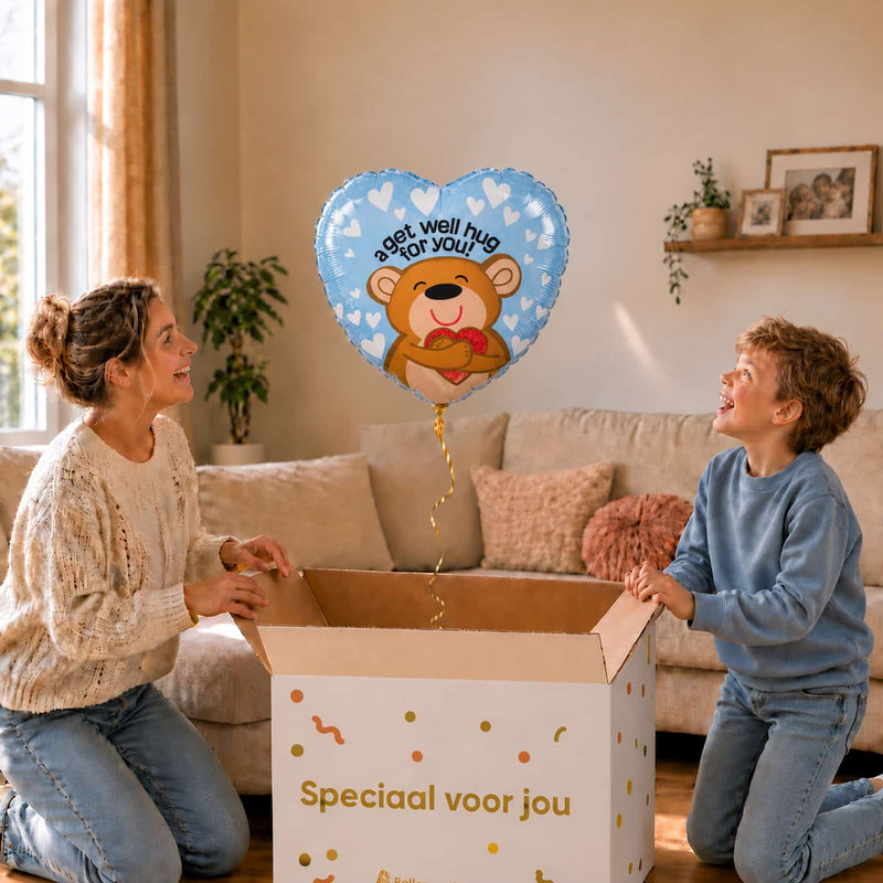 Moeder en kind bekijken een blauwe hartvormige beterschapsballon met een beertje en de tekst A get well hug for you.