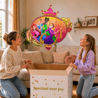 Moeder en meisje bekijken een Disney-prinsessenballon met Ariel, Assepoester, Tiana en Rapunzel van 86 cm met gouden lint boven de geopende cadeaudoos ‘Speciaal voor jou’.