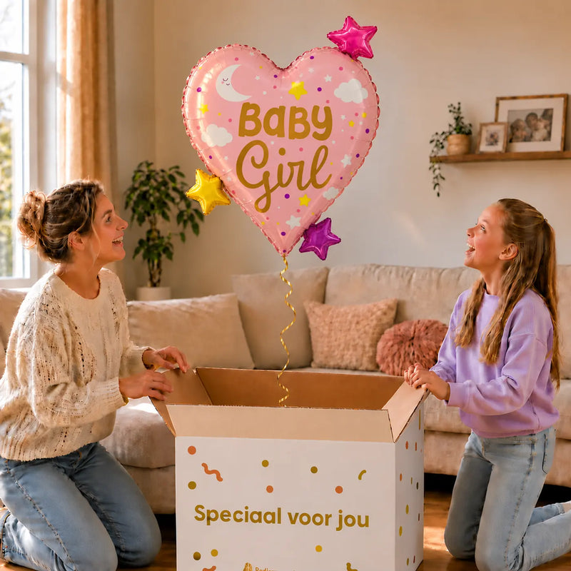 Baby Girl Hart Sterren XL Ballon zweeft boven een geopende cadeaudoos bij een moeder en meisje in een warme woonkamer.